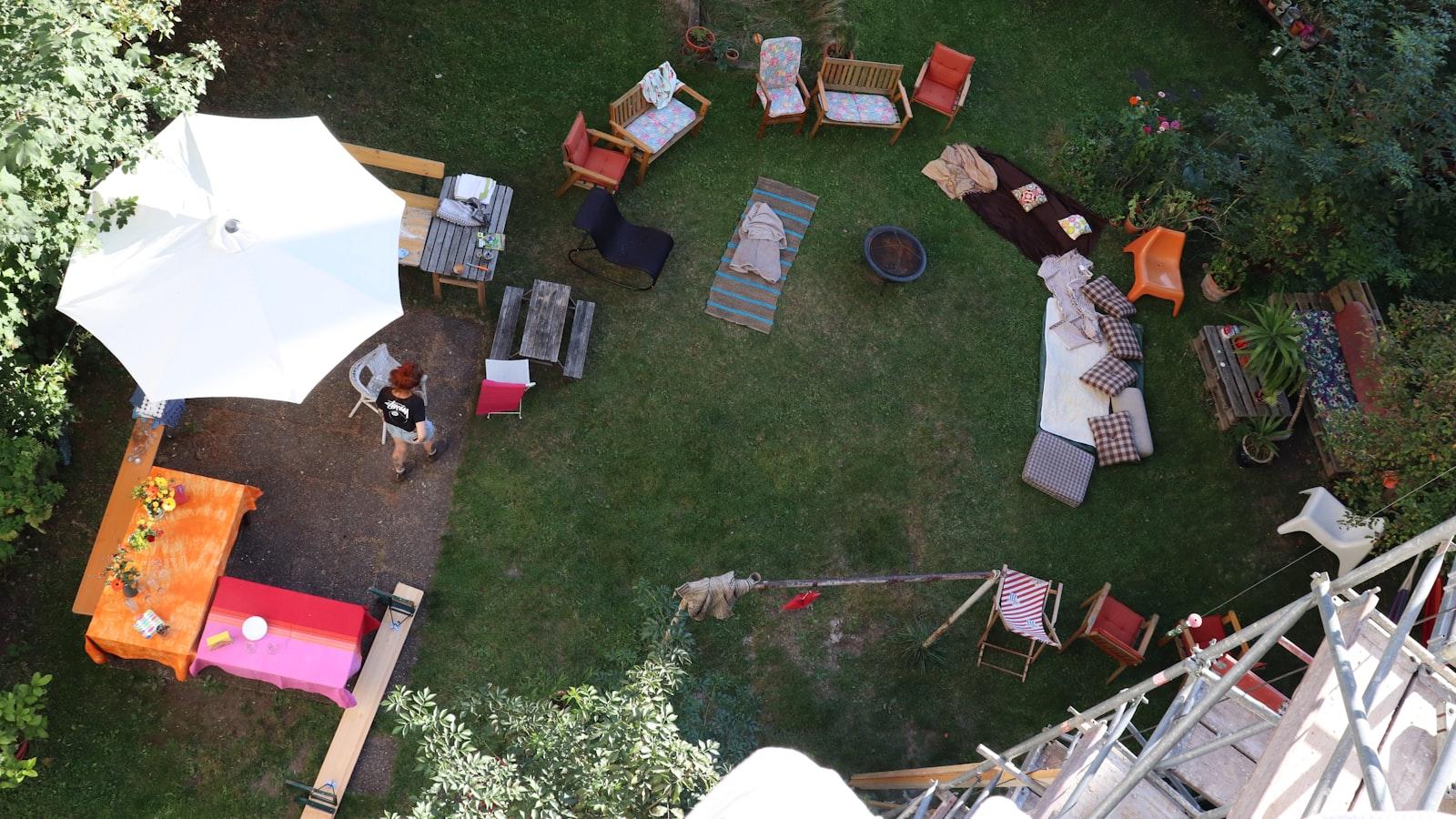 A backyard set up for a celebration, seen from above, with tables, a tent and lights