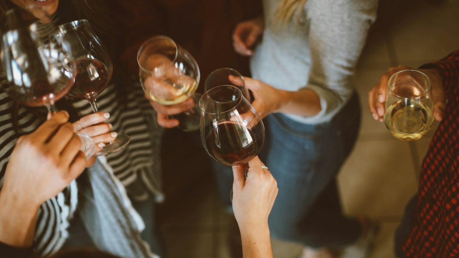 A group of friends raising wine glasses in a toast at an evening celebration